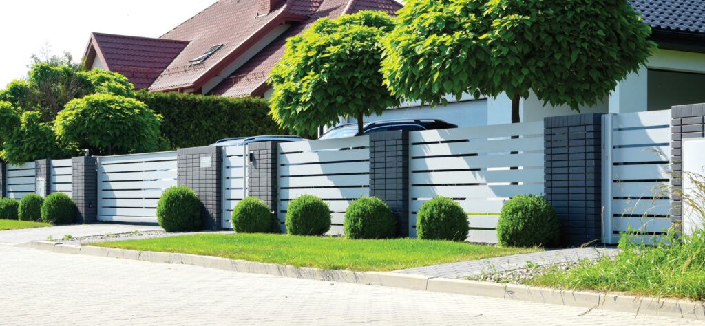 Piękne ogrodzenie aluminiowe, malowane proszkowo na biało, z poziomymi przęsłami.