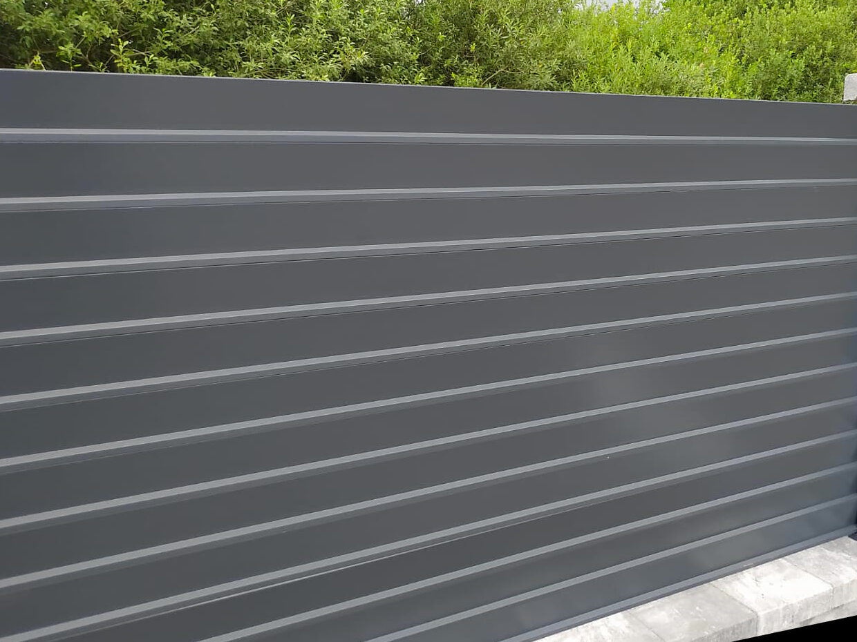 Zbliżenie na ogrodzenie aluminiowe żaluzjowe w kolorze antracytowym. 