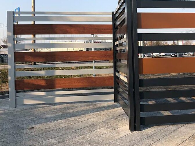 Na zdjęciu dwa różne przykłady jak można imitować drewno używając aluminium w produkcji ogrodzeń. 